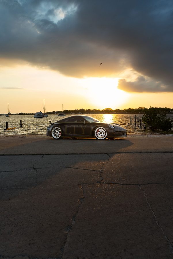 Wide front three-quarter view of the GT3 on the seawall under storm light