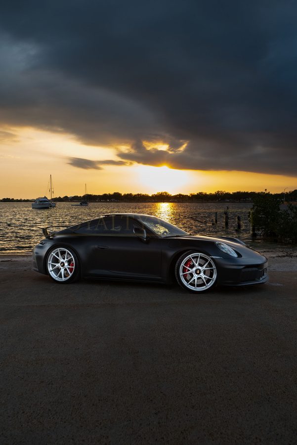 Front three-quarter of the GT3 under storm light on the seawall
