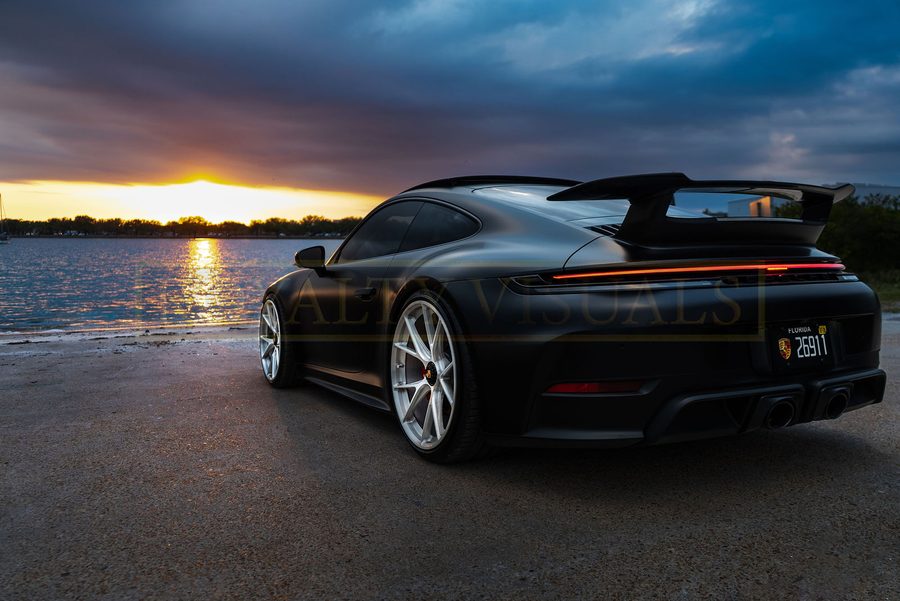 Rear three-quarter of the GT3, swan-neck wing, water behind