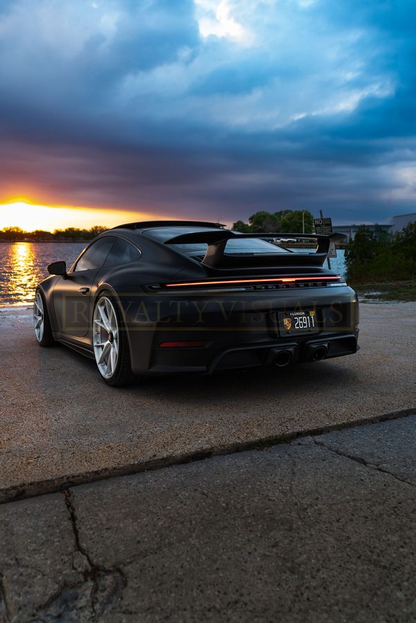 Low rear three-quarter of the GT3 under a dramatic storm sky