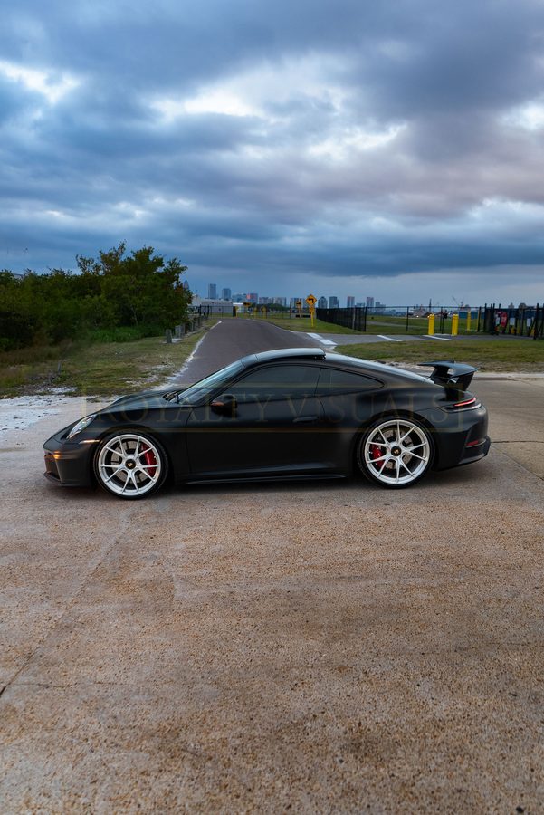 Pure side elevation of the satin-black 992 GT3 on a road at Davis Islands, Tampa skyline behind