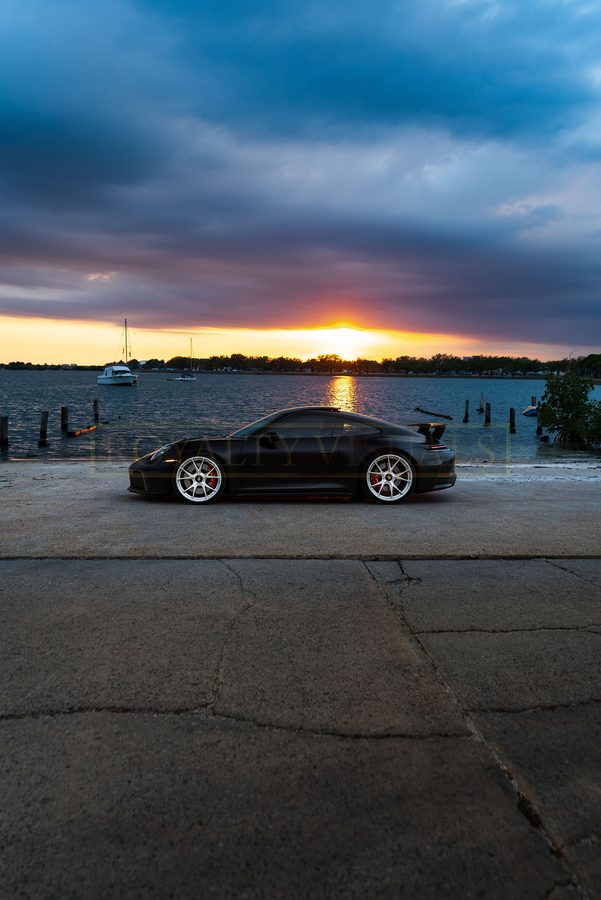 Wide rear three-quarter of the GT3, sunset over the bay