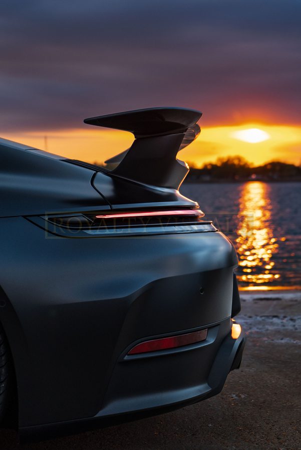 Detail of the GT3 rear wing and tail with the sun setting over the water